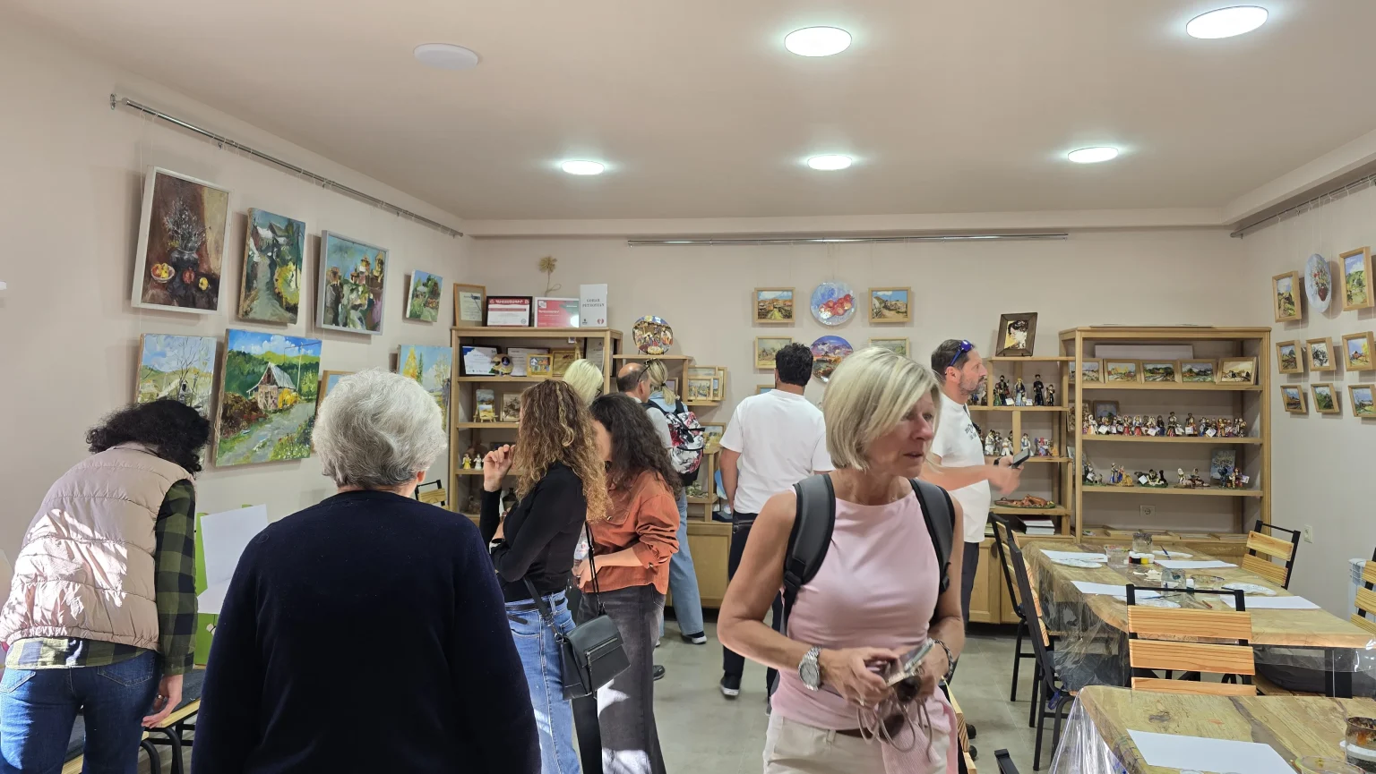 The gallery hall in Hatsik with visitors walking along the painted walls